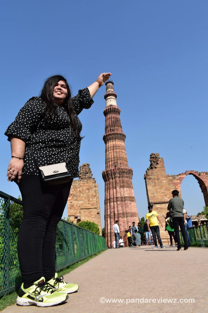 holding qutub minar photo